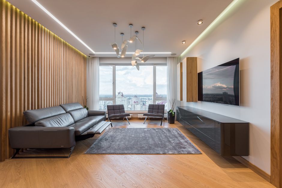 Contemporary large living room with carpet and armchairs with long sofa in daylight